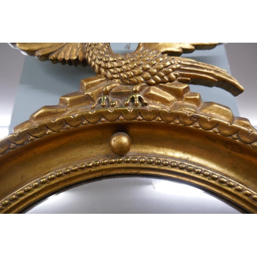 283 - Gilt framed convex mirror adorned with eagle
