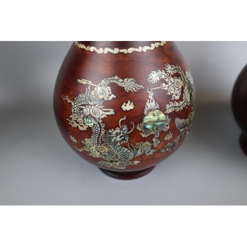 69 - Pair of rosewood vases inlaid with mother of pearl depicting dragons - Approx. H: 40cm