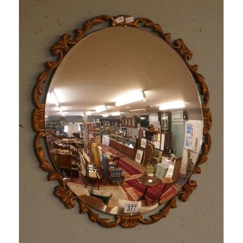 377 - Round ornate convex mirror with gilt frame