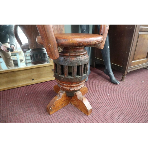 342 - Unusual carved swivel armchair on antique cartwheel hub base