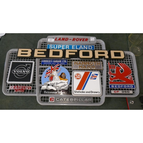 237 - Collection of badges to include Bedford and Britannia trucks mounted on a Land Rover grill