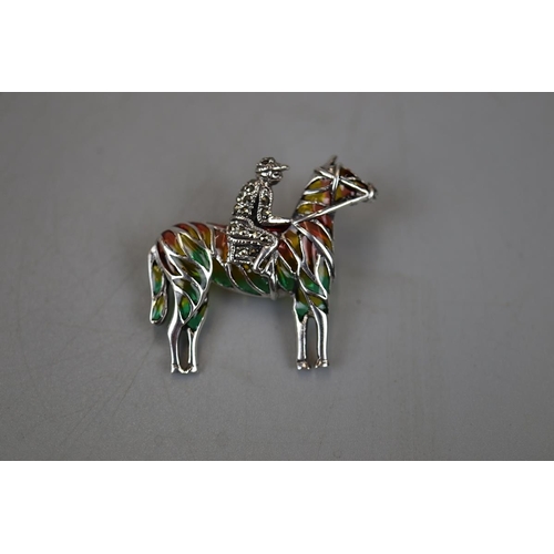 23 - Silver enamel horse and jockey brooch