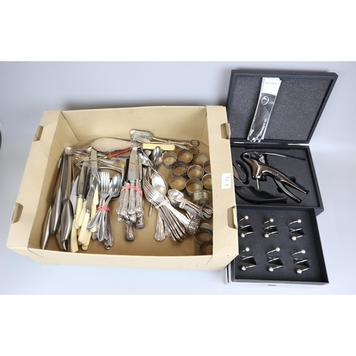 121 - Collection of flatware to include napkin rings and Le Creuset bottle opener