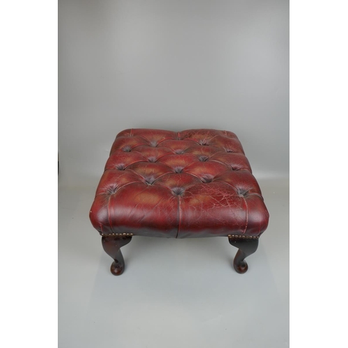 379 - Ox-blood leather wing back chair together with matching stool