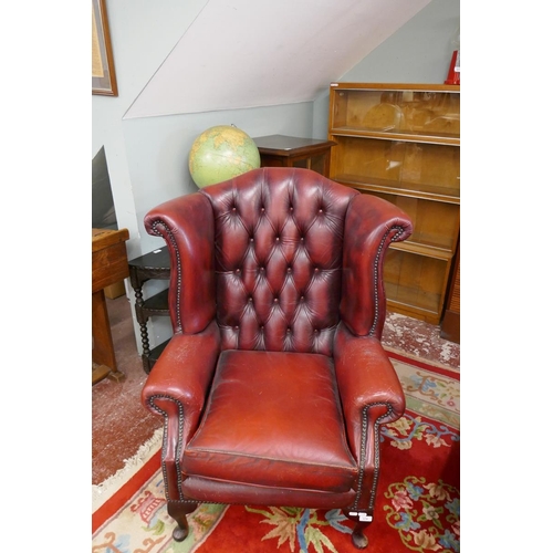 379 - Ox-blood leather wing back chair together with matching stool