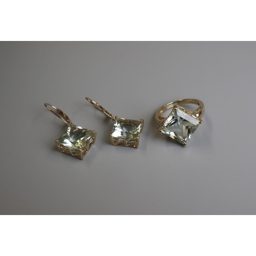 138 - Gold blue topaz ring (size K) together with a matching pair of drop earrings 