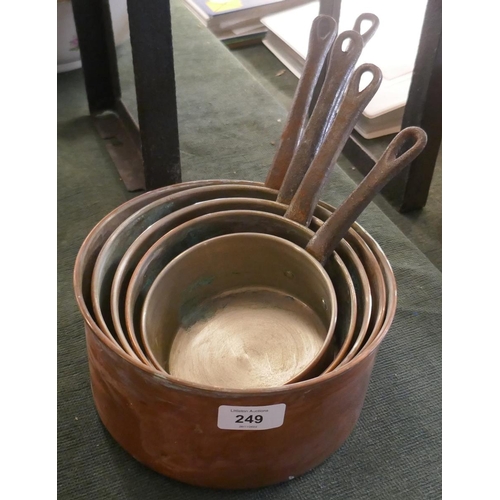 249 - Graduated copper saucepans with plate