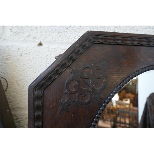 468 - Black octagonal oak framed wall mirror together with an oak framed horseshoe mirror