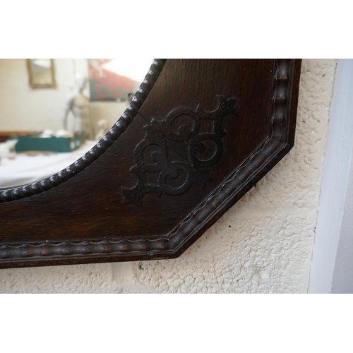 468 - Black octagonal oak framed wall mirror together with an oak framed horseshoe mirror