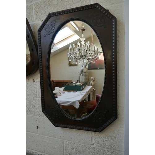 468 - Black octagonal oak framed wall mirror together with an oak framed horseshoe mirror