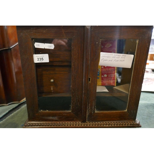 235 - Edwardian glazed oak smokers cabinet with contents