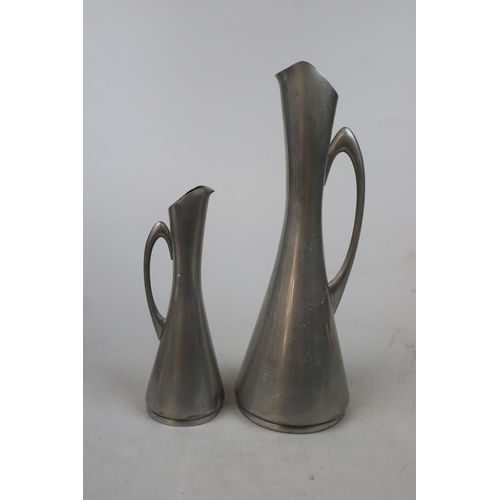 191 - Graduated pair of Norwegian Modernist pewter jugs together with a pewter plate and 4 pewter napkin r... 