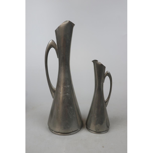 191 - Graduated pair of Norwegian Modernist pewter jugs together with a pewter plate and 4 pewter napkin r... 