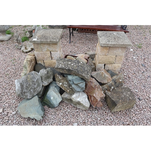 387 - Rockery stone together with 2 capped stone pillars