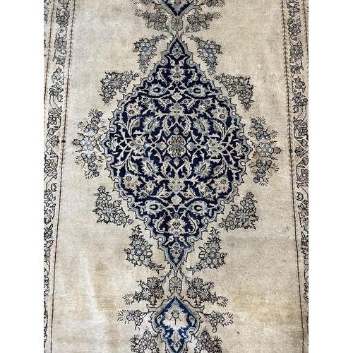 293 - Cream & blue patterned antique rug - Approx size: 275cm x 158cm