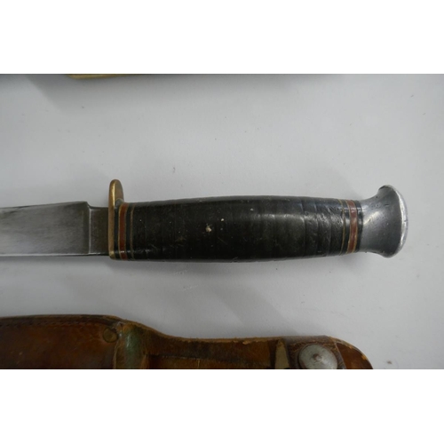 387 - German folding bowie knife in sheath together with a fighting knife in sheath marked William Rogers ... 