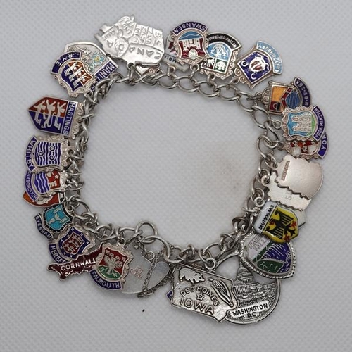 65 - A silver charm bracelet with crest charms - Approx weight 52g
