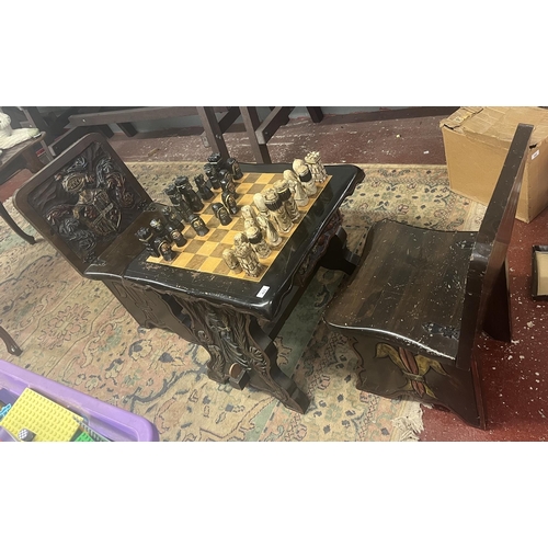 423 - Bespoke carved chess table with 2 matching folding chairs together with carved chess pieces in drawe... 