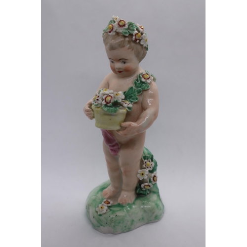 175 - A porcelain figure of a putto on flower encrusted base