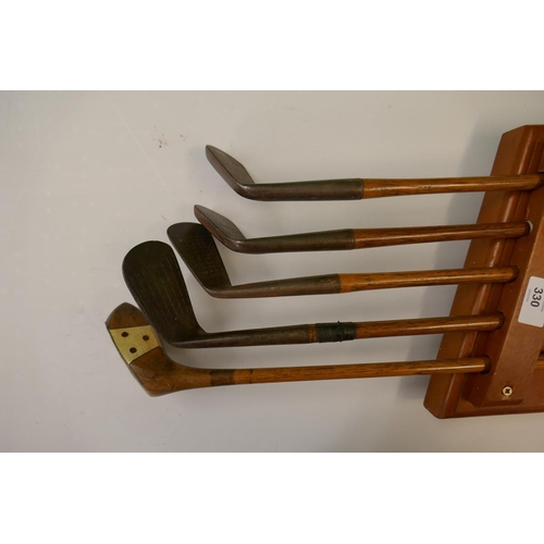 330 - Vintage golf clubs on presentation rack