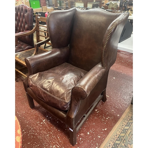 583 - Brown leather wing back armchair