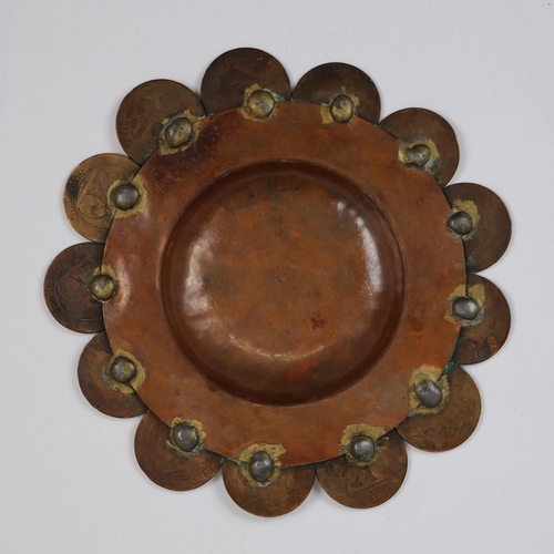 103 - Hand beaten copper pin dish with a ring of integrated coins