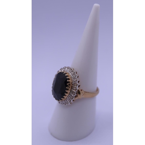 43 - 9ct gold ring set with a large sapphire & diamonds - Size M