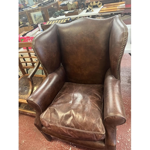 583 - Brown leather wing back armchair