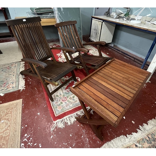 688 - 2 teak chairs together with a teak campaign style table