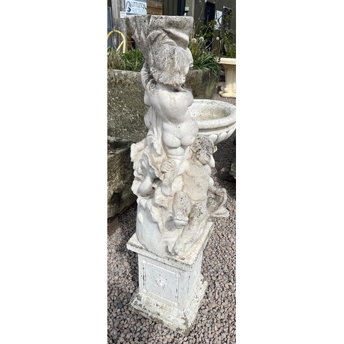 497 - Stone pedestal adorned with cherubs and dolphins on stone base - Approx height: 138cm