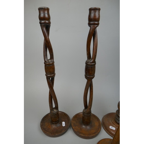 254 - Pair of tall wooden candlesticks together with 2 others