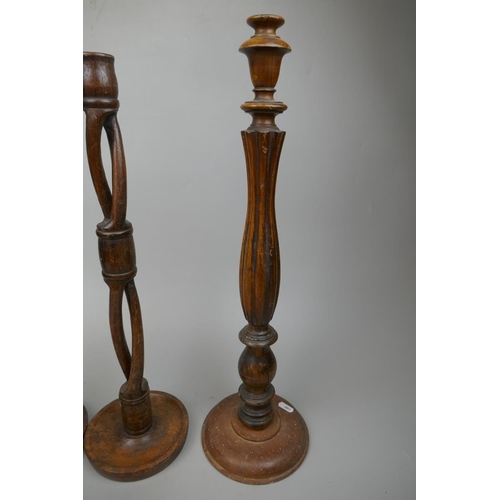 254 - Pair of tall wooden candlesticks together with 2 others