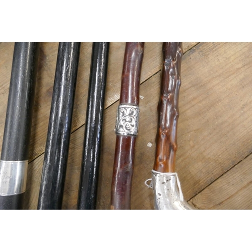 275 - 4 ebonized walking canes with hallmarked silver collar, handle and tips together with 2 possibly Bla... 