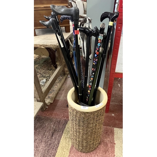 258 - Ceramic and wickerwork stick stand with shooting stick and walking sticks