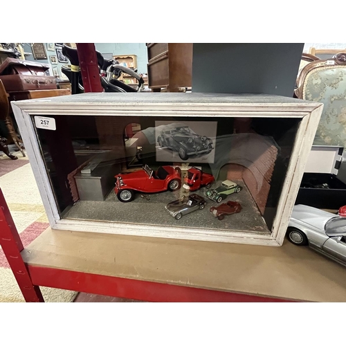 257 - Collection of model cars together with a display case