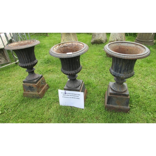 254 - A set of 3 fluted cast-iron urns on pedestals - Approx Height: 72cm  Diameter: 41cm