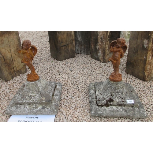 302 - Pair of cast iron fairies on stone plinths