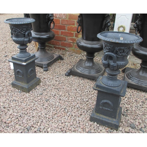 351 - Pair small cost iron urns on plants