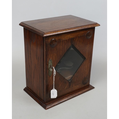 140 - Edwardian oak bevelled glazed smoker's cabinet with sprung drawer and key