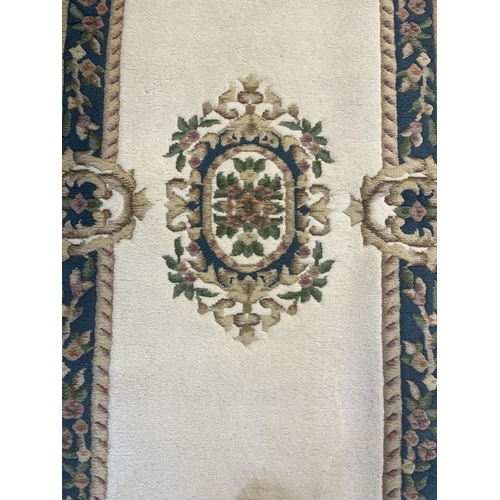 439 - Pair of white ground embossed all wool long rugs  - Approx size 189cm x 92cm