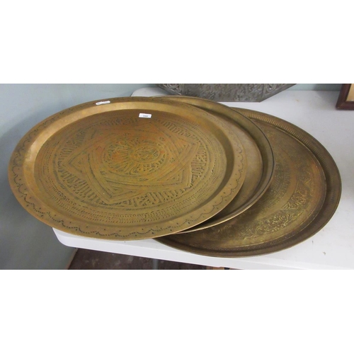 396 - 3 large engraved brass chargers. Approx 60 cm diameter.