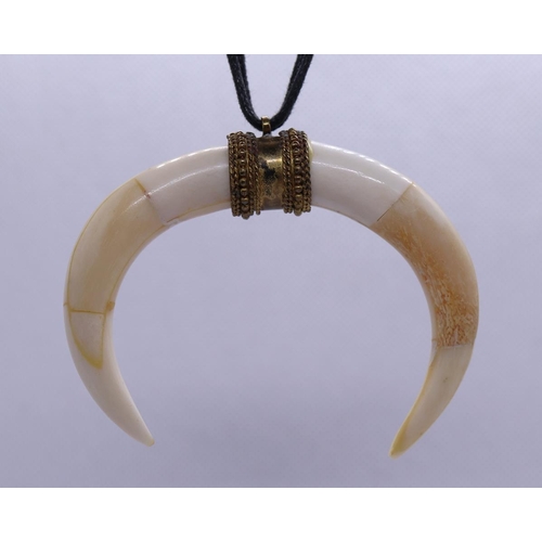 64 - Bone pendent with gilt setting on leather necklace