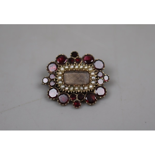 54 - 9ct gold garnet & seed pearl mourning brooch