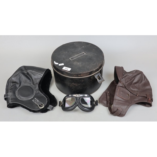 114 - Black enamel military Hat box (tin) contents 2 aviator caps and a pair of goggles