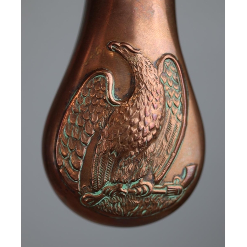 137 - A vintage copper and brass colt pistol powder flask featuring an embossed eagle together with an ant... 