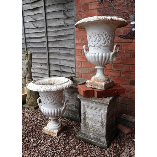 549 - Pair of cast iron urns togther with 2 stone plinths