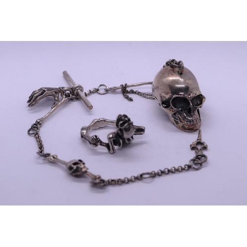 76 - Silver Albert chain in the form of a skull and hand together with a silver creeping skull ring