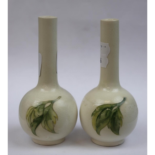 169 - Pair of small Moorcroft bottle vases queen Mary paper labels to the base - Approx height 12cm