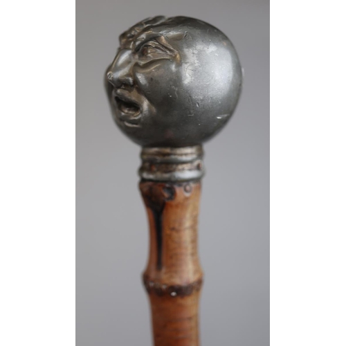 138 - Bamboo walking stick with pewter handle in the form of a Victorian grotesque man being stung by a be... 