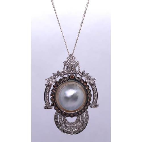 40 - 18ct white gold pendant centrally set with a mabe pearl surrounded by champagne diamonds & borde... 